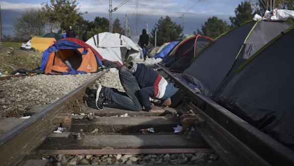 A man prays between rail tracks at the Greek-Macedonian border, near the Greek village of Idomeni on Sunday. More than 600,000 refugees and other migrants have entered Europe through Greece this year, many after making the short sea crossing from Turkey. 