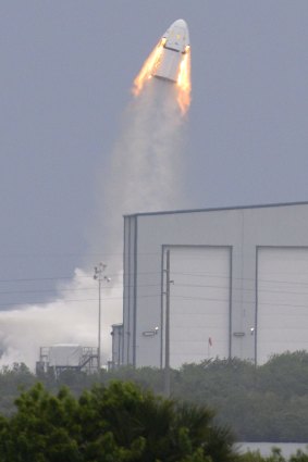 A SpaceX Dragon mock-up capsule blasts into the air.