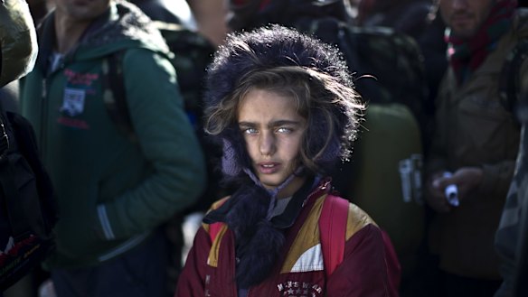 Yazidi refugee Salma Bakir, 9, from Iraq, waits with her family to be permitted by Macedonian police to board a train heading to the Serbian border last year.