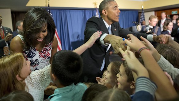 Historic visit: Barack Obama and wife Michelle greet families of embassy personnel in Havana. 