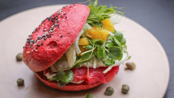 House-made beetroot bagel filled with salmon, watercress and egg.