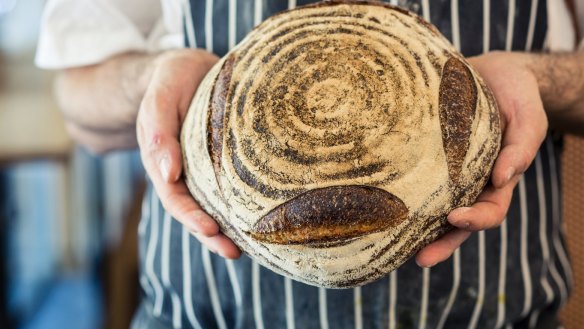 Michael James with one of his loaves of bread made from spelt flour milled at Tivoli Road bakery in Melbourne. 