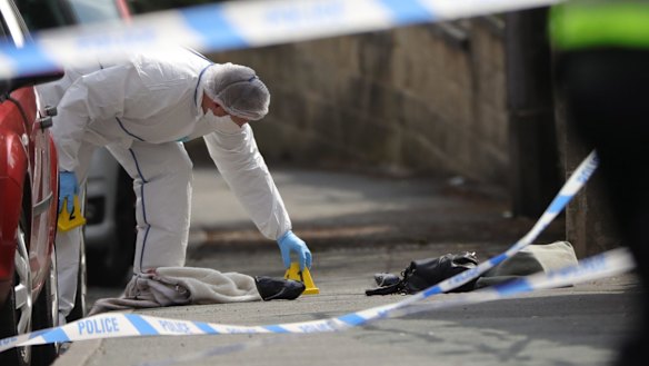 Forensic police examine shoes and a handbag at the scene.