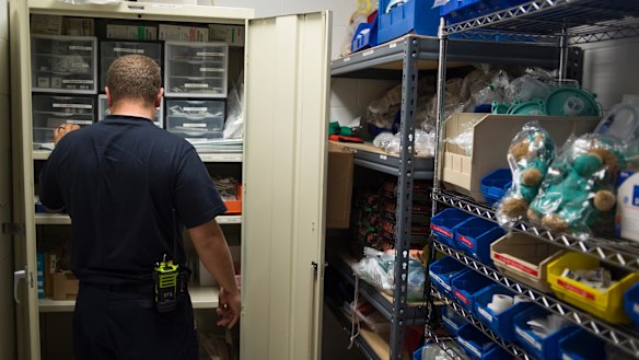 Doug Rolf, a firefighter and medic restocks medicine after responding to an overdose, in Colerain, Ohio.