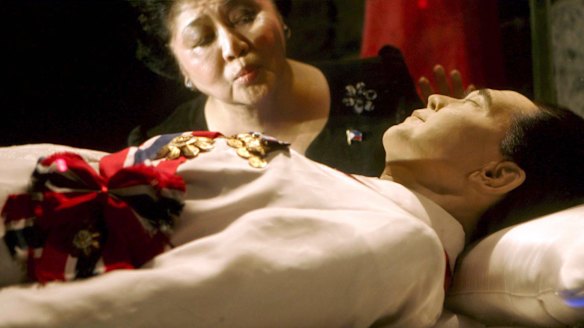 Imelda Marcos kisses the refrigerated crypt of her husband at a mausoleum in Batac, Philippines, in 2005.