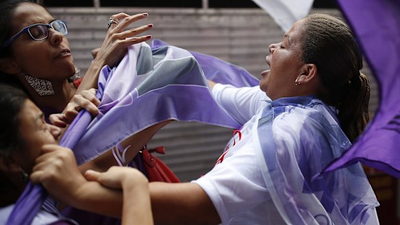 Anti-government demonstrators clash with a supporter of Dilma Rousseff on International Women's Day in Sao Paulo last week.