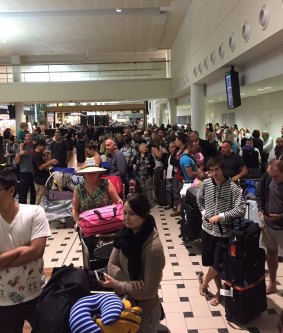 Passengers queue at Brisbane airport after their Jetstar flight was cancelled after more than 24 hours' delay.
