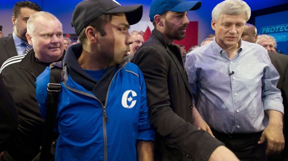 Stephen Harper finds himself a little close for comfort to notorious former Toronto mayor Rob Ford, left, at a campaign rally in the city at the weekend.