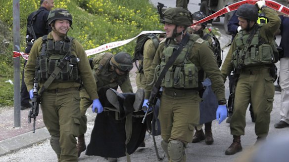 Israeli soldiers carry the body of Abdel Fattah Sharif from the scene of the incident in the Israeli-occupied West Bank city of Hebron. 