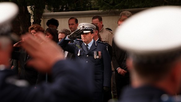 Chief commissioner Neil Comrie salutes at the funeral of Gary Silk.