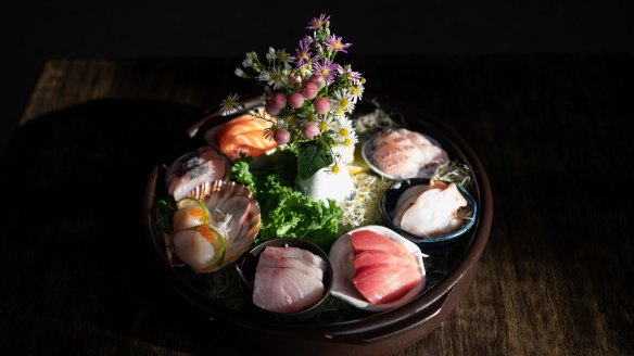The sashimi platter is pretty presented with flowers.