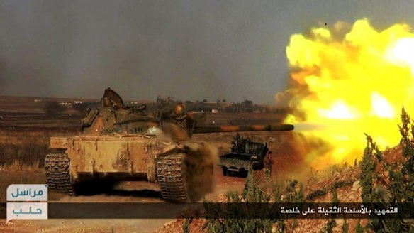 A rebel tank firing at Syrian troops at the hilltop of Khalsa village, southern Aleppo,  in June.