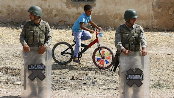 Turkish soldiers at the border gate near the Syrian town of Kobane, a key battleground between Kurdish militias and the forces of Islamic State.
