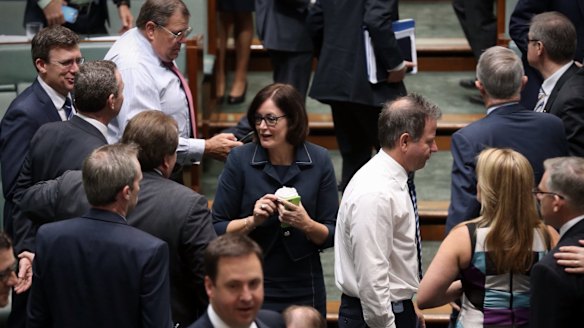 MPs cross the floor during a division at Parliament House.