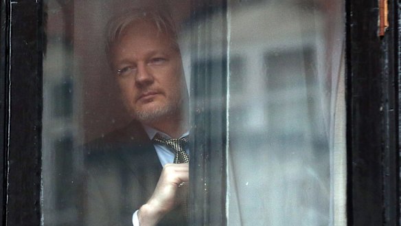 Julian Assange looks out from the Ecuadorian embassy in London,  where he took refuge in June 2012 to avoid extradition to Sweden.