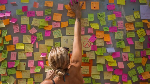 A woman leaves a message on a memorial board on Barcelona's historic Las Ramblas promenade on Friday.
