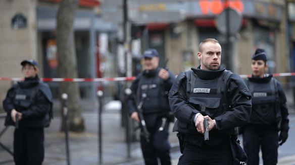 Police officers secure the perimeter near the scene of a fatal shooting and suspected terrorist attack that took place at a police station in Paris, Wednesday.