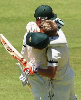 Brothers in arms: Michael Clarke and David Warner embrace after Warner reached his century on Tuesday.