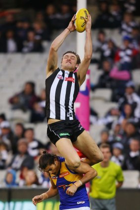 Collingwood's Darcy Moore takes a spectacular grab over Sharrod Wellingham.