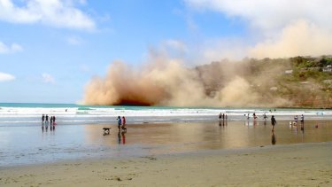 Dust clouds rise in Sumner following Sunday's large earthquake near Christchurch.
