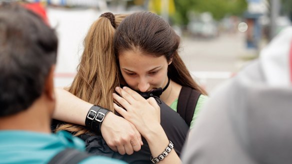 People mourn near the crime scene at OEZ shopping centre.