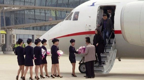 Air Koryo cabin crew greet passengers with flowers at Pyongyang's Sunan airport last month as the first Air Koryo flight of the new service from Dandong, China, touched down. 