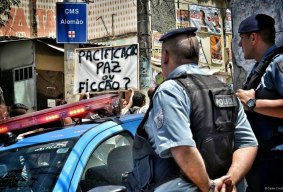 Residents protest against Rio government's favelas "pacification" policy. The sign reads "pacification or fiction?".