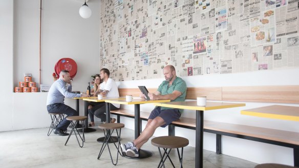 Yellow Fever's bright, airy interior features a newspaper-papered wall.