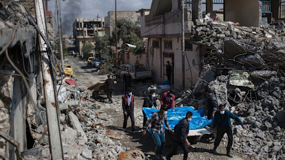 Residents carry the bodies of several people killed during fights between Iraq security forces and Islamic State on the western side of Mosul.