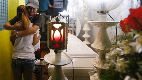 Kian's father, Saldy Delos Santos, comforts his son's girlfriend at the wake.