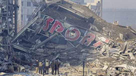 People examine the damage after shelling of a shopping center, in Kyiv, Ukraine, Monday, March 21, 2022. Eight people were killed in the attack. (AP Photo/ (AP Photo/Efrem Lukatsky)