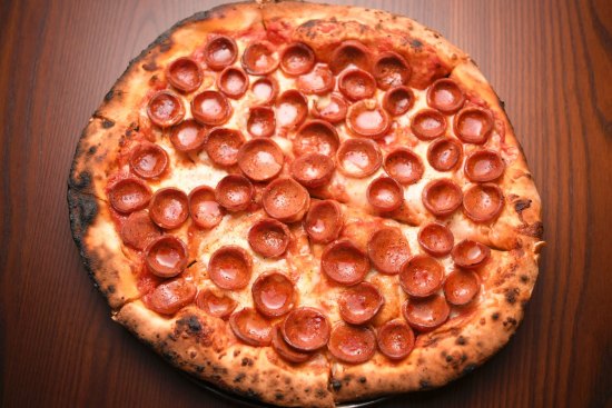 Pepperoni pizza is assembled with precision.