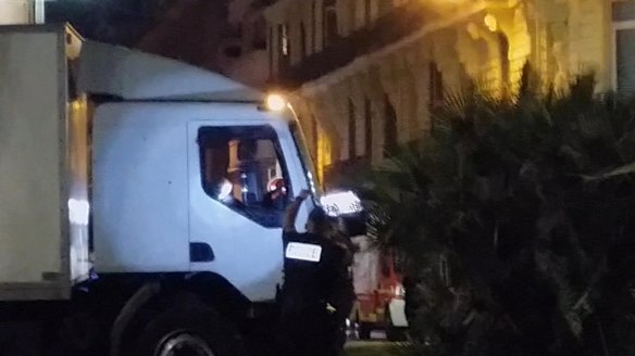 Police shine a light in the cab of a truck which ploughed into a crowd in Nice, killing 84. 