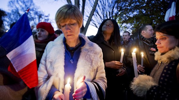 Alexandra Salomon, from Paris, France, centre, joins a vigil outside the White House in Washington DC.