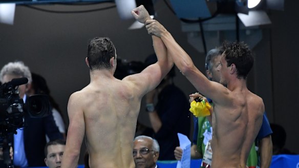 Cameron McEvoy, right, raises Kyle Chalmers' arm in triumph.
