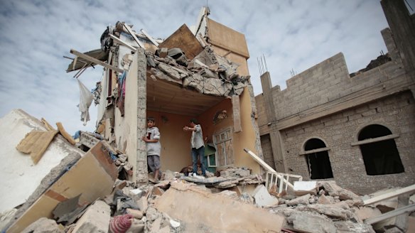 Boys stand on the remains of a house destroyed by Saudi-led airstrikes in Yemen in August.  
