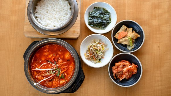 The signature tofu soup, sundubu-jjigae (bottom left), comes with banchan (snacks) and rice.