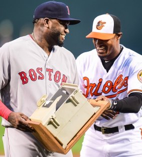 All smiles: Baltimore's Adam Jones hands the gift over to David Ortiz.