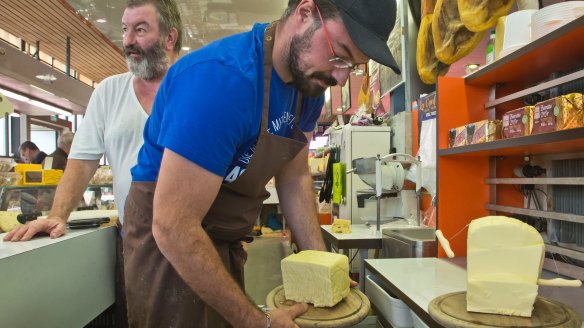 Nicolas Chatel takes away the a piece of butter as Pierre Chatel stands behind him at the market in Marly le Roi, west of Paris, France.