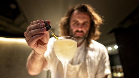 Luke Whearty, co-owner of Byrdi bar, adds bitters to a martini.