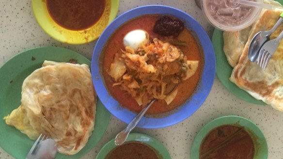 Prata bread and dipping sauce (lontong rice cake, cabbage and tofu curry, centre). 
