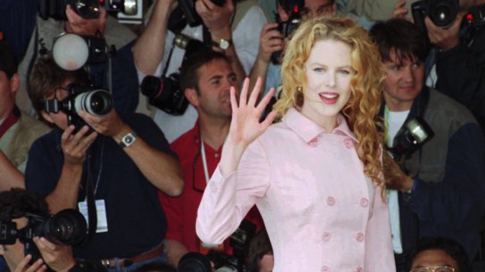 Nicole Kidman, waves to photographers before her press conference for the film " To Die For".