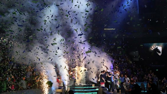 Members of Team Liquid raise the winning trophy.