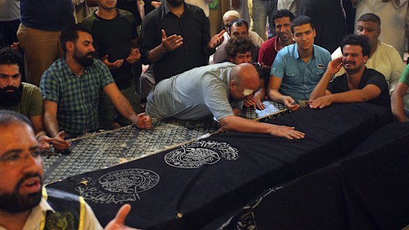 Mourners grieve on Tuesday by coffins of bomb victims, Saad Samed, 28, and his wife Mariam Aqeel, 22, and his sons Mohammed Saad, 7, and Ahmed Saad, 5, who killed at an open-air market in Baghdad's northern neighbourhood of Shaab.