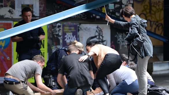 Witnesses help the injured on Bourke Street.