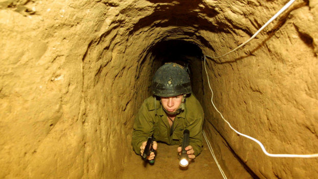 Fighting underground: An Israeli soldier crawls through a tunnel built by Palestininans from the Gaza Strip town of Rafah into Egypt which the Israeli army discovered in May, 2002. 