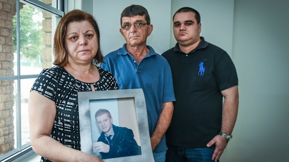David and Sylvia Veljanovski with their son Jim Veljanovski and a portrait of missing Nick at their Yagoona home.