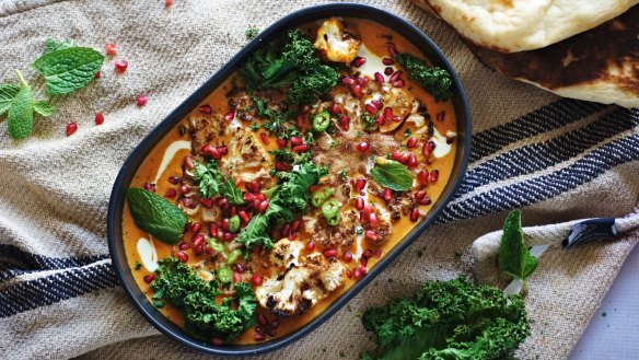 Garam masala roasted cauliflower in coconut and saffron curry with pomegranate and kale.
