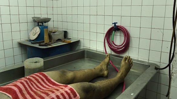 An unidentified male body lays on the table at a funeral home in Manila. He was found early Easter Sunday with his head wrapped in packing tape, his eyes gouged out, hands tied by steel wire, stabbed with an ice pick and shot.