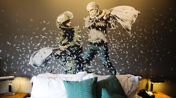 Banksy's wall painting showing an Israeli border policeman and a Palestinian in a pillow fight in one of the suites of the Walled Off Hotel.